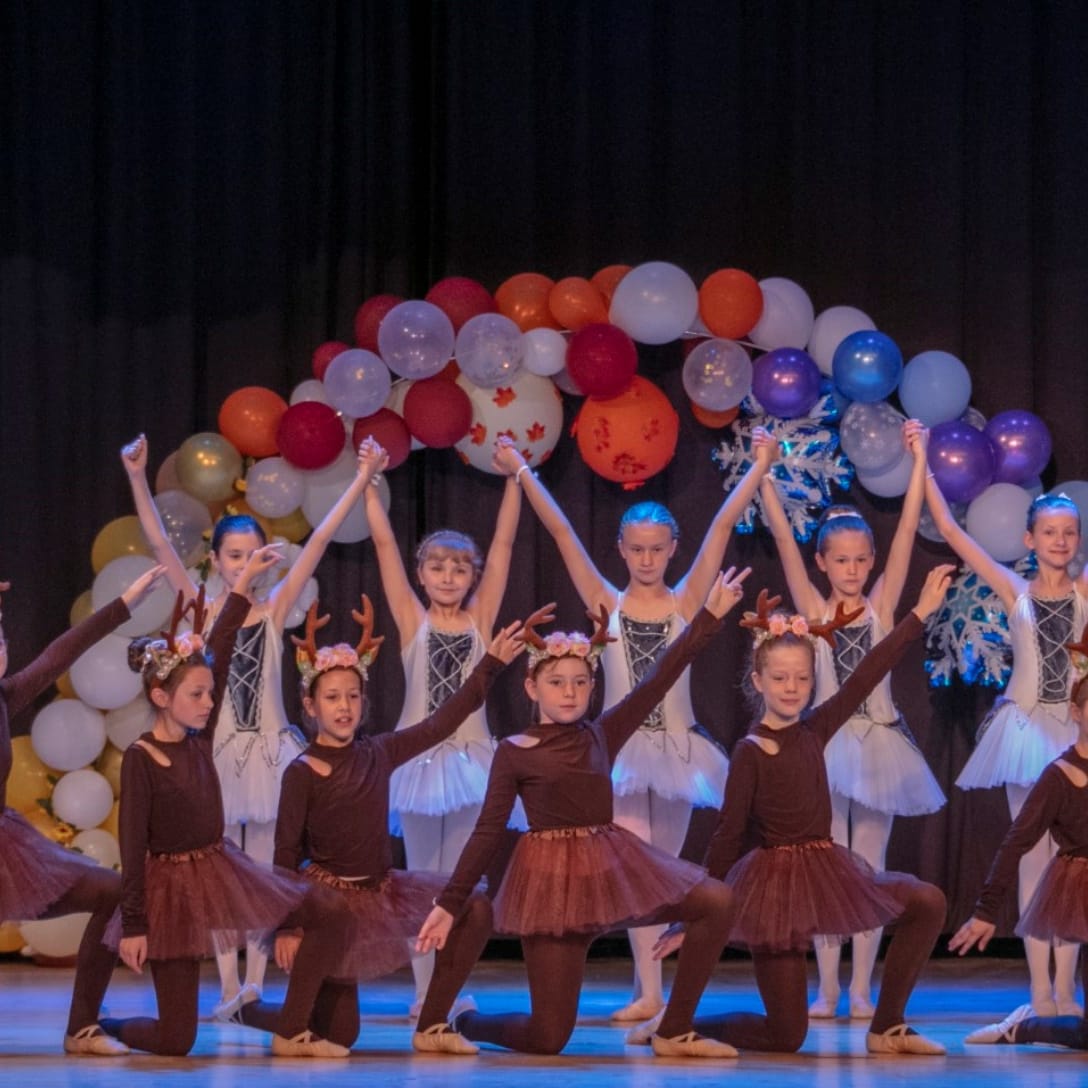 Ballett-Formation bei einem Auftritt vor einem Ballonbogen